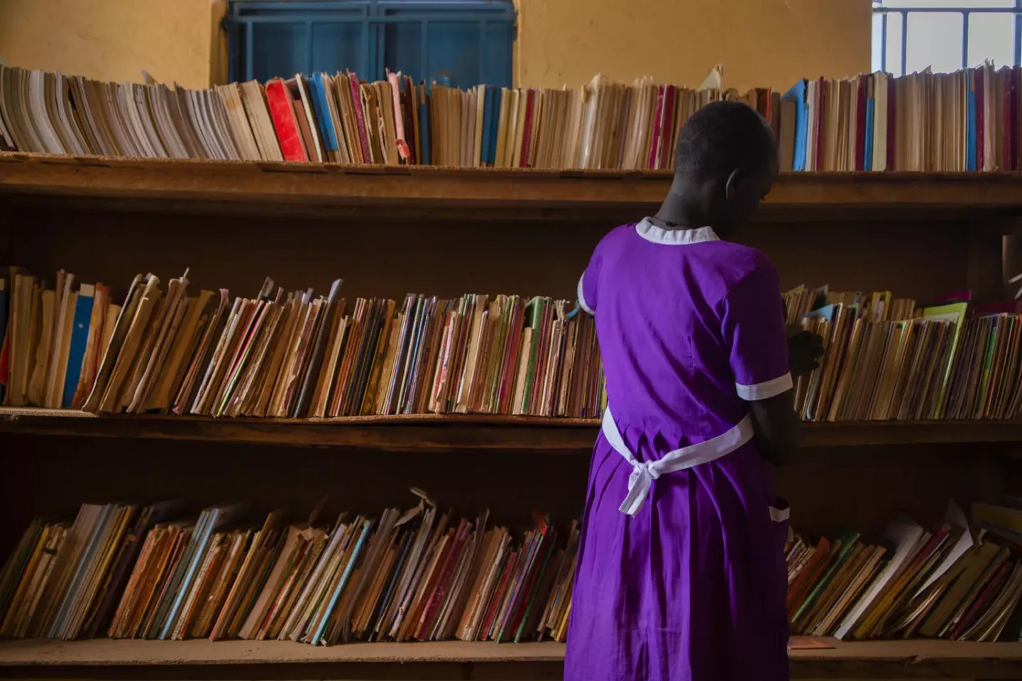 Student searches for books in a library.