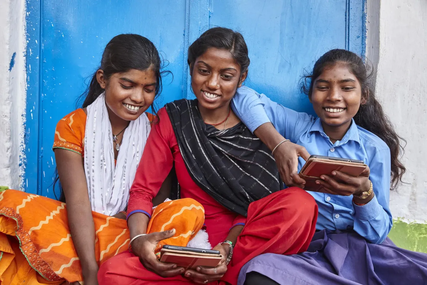 Three friends explore learning through digital devices at school in Bihar, India.