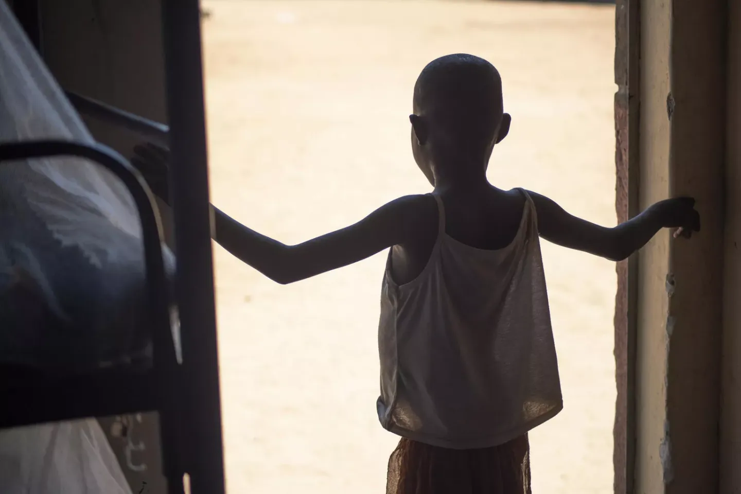 An 8-year old, the youngest who has been rescued being circumcised stands at the entrance of one of the buildings at Kalas Girls School Amudat District