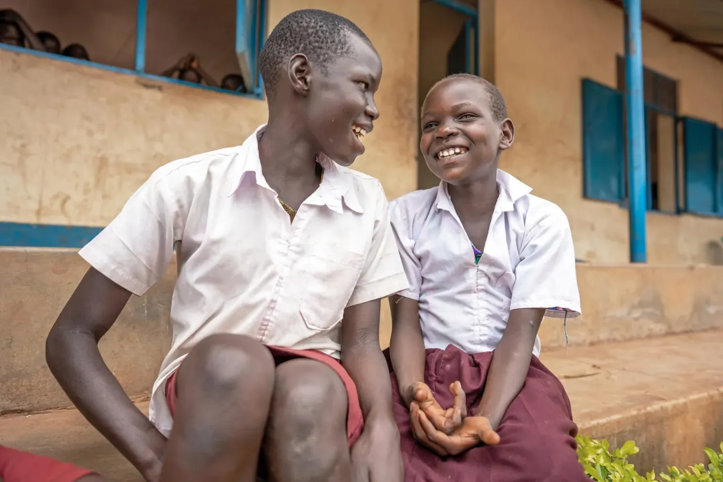 Two students sit outside their classroom in South Sudan. 