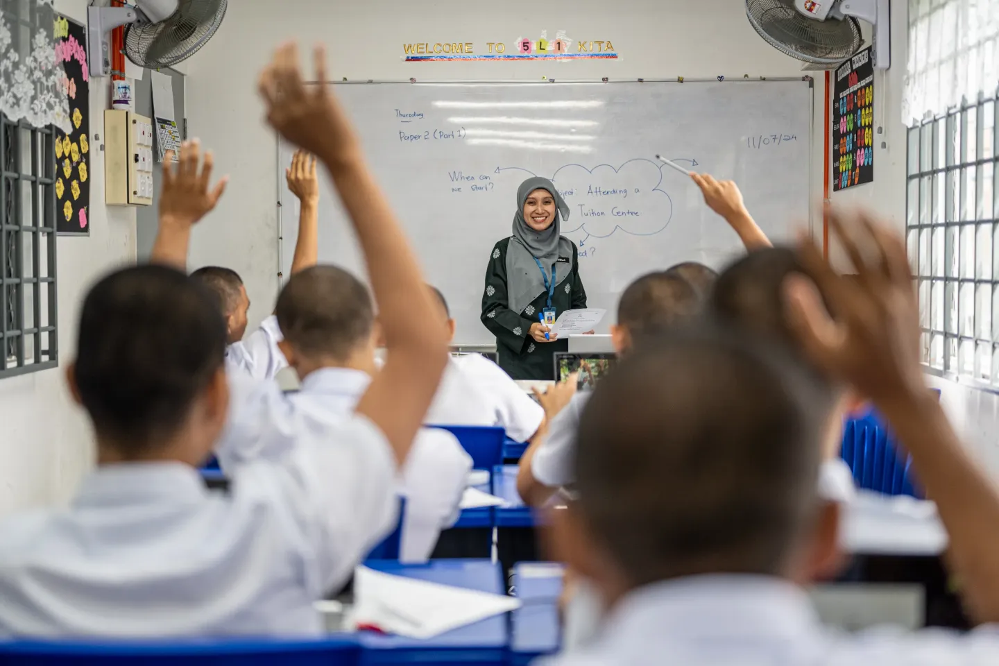 Students in class raising their hands