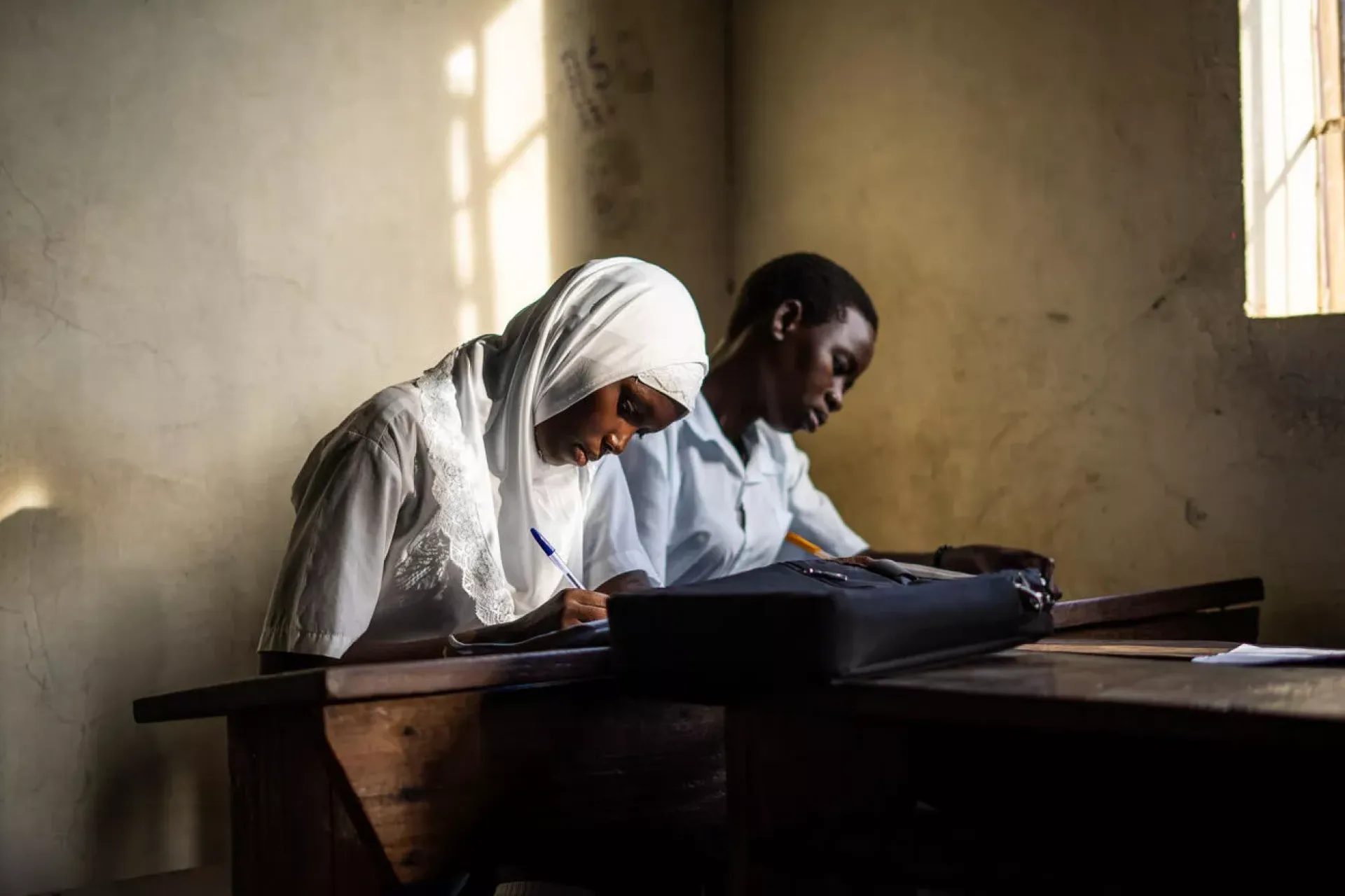 Fancy Munguci, 23, (veiled) prepares for a History examination - a national paper organized by the Uganda National Examinations Board (UNEB).